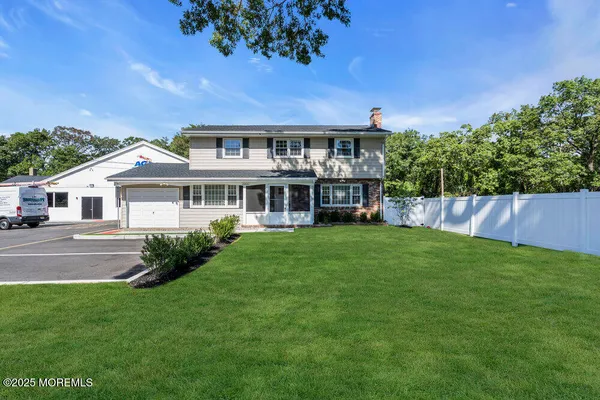 a front view of a house with a yard and potted plants