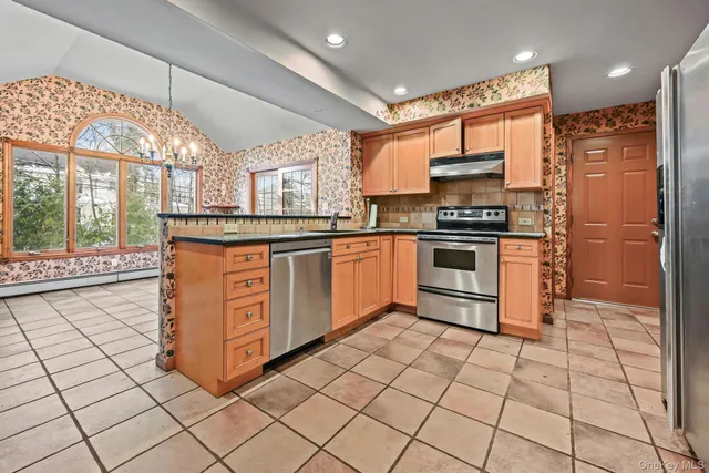 a kitchen with stainless steel appliances granite countertop a stove a sink and a refrigerator