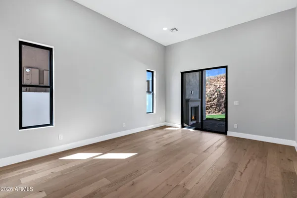 an empty room with wooden floor and windows