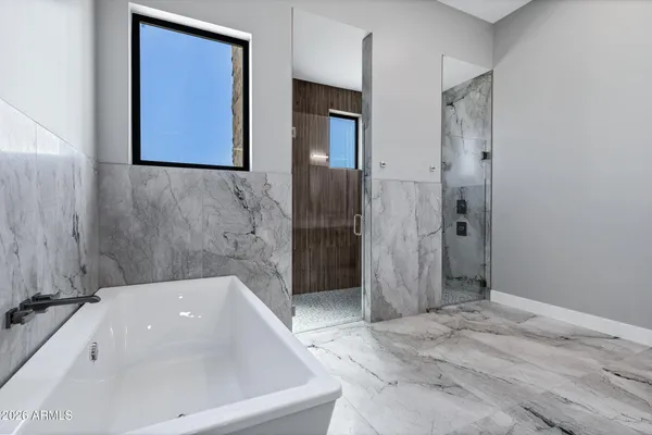 a spacious bathroom with a double vanity sink mirror and bathtub