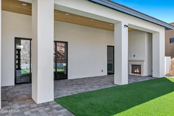 a view of a porch in front of a house with a big yard