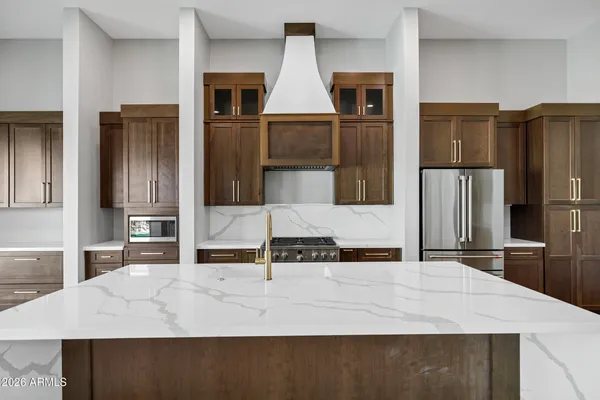 a kitchen with stainless steel appliances granite countertop a refrigerator and a stove top oven