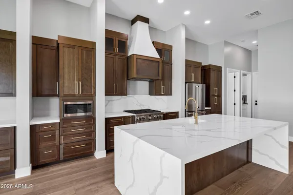 a kitchen with stainless steel appliances granite countertop a refrigerator and a stove
