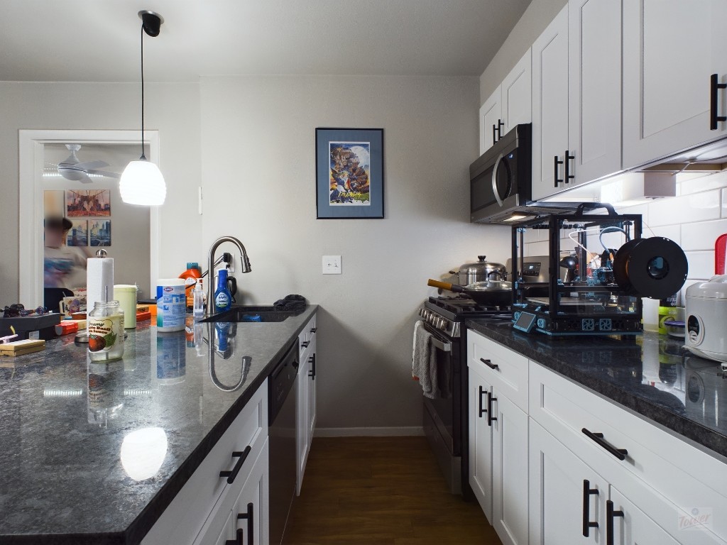 304 East 33rd Street, Unit 8 Austin, TX 78705 - Photo 8 of 14 a kitchen with stainless steel appliances granite countertop a sink a stove and a wooden cabinets