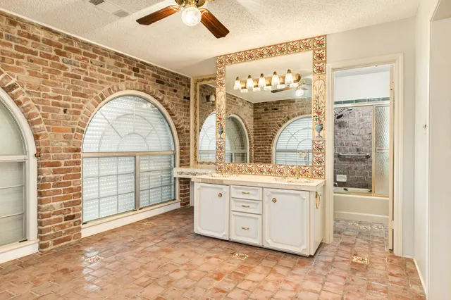 a bathroom with a granite countertop sink mirror and bathtub