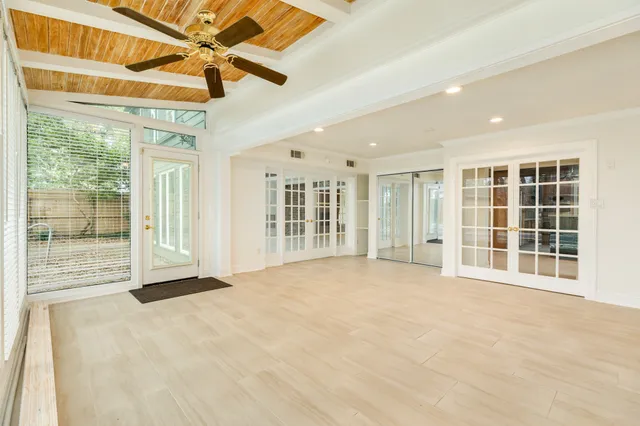 a view of an empty room with a window and a ceiling fan