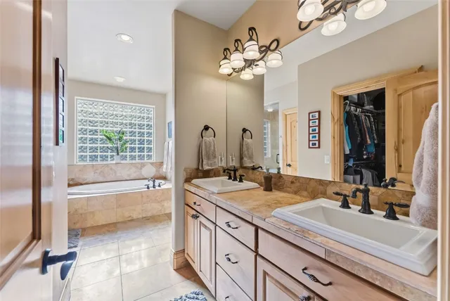 a bathroom with a granite countertop sink a large mirror and a bathtub with shower