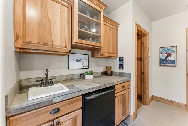 a kitchen with stainless steel appliances granite countertop a sink and dishwasher with wooden cabinets