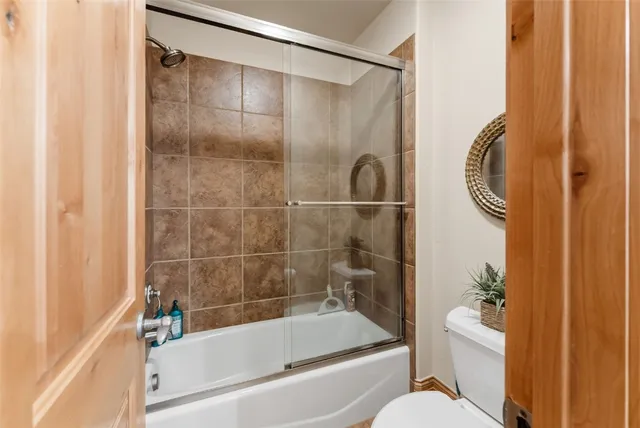 a bathroom with a granite countertop bathtub shower and toilet