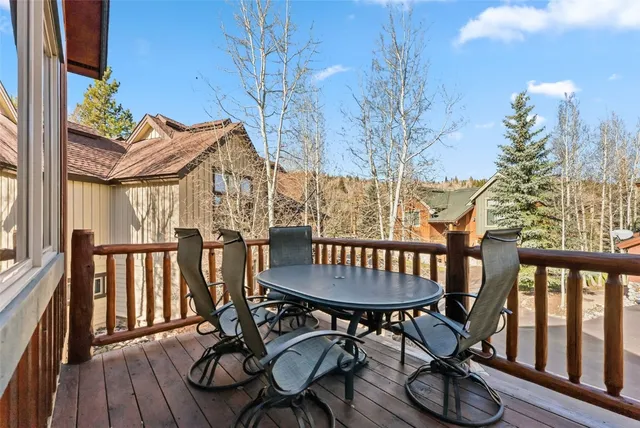 a view of a patio with table and chairs with wooden floor and fence