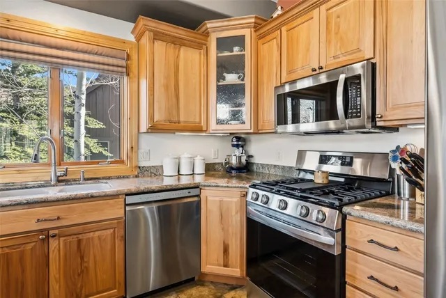 a kitchen with stainless steel appliances granite countertop a stove and a microwave
