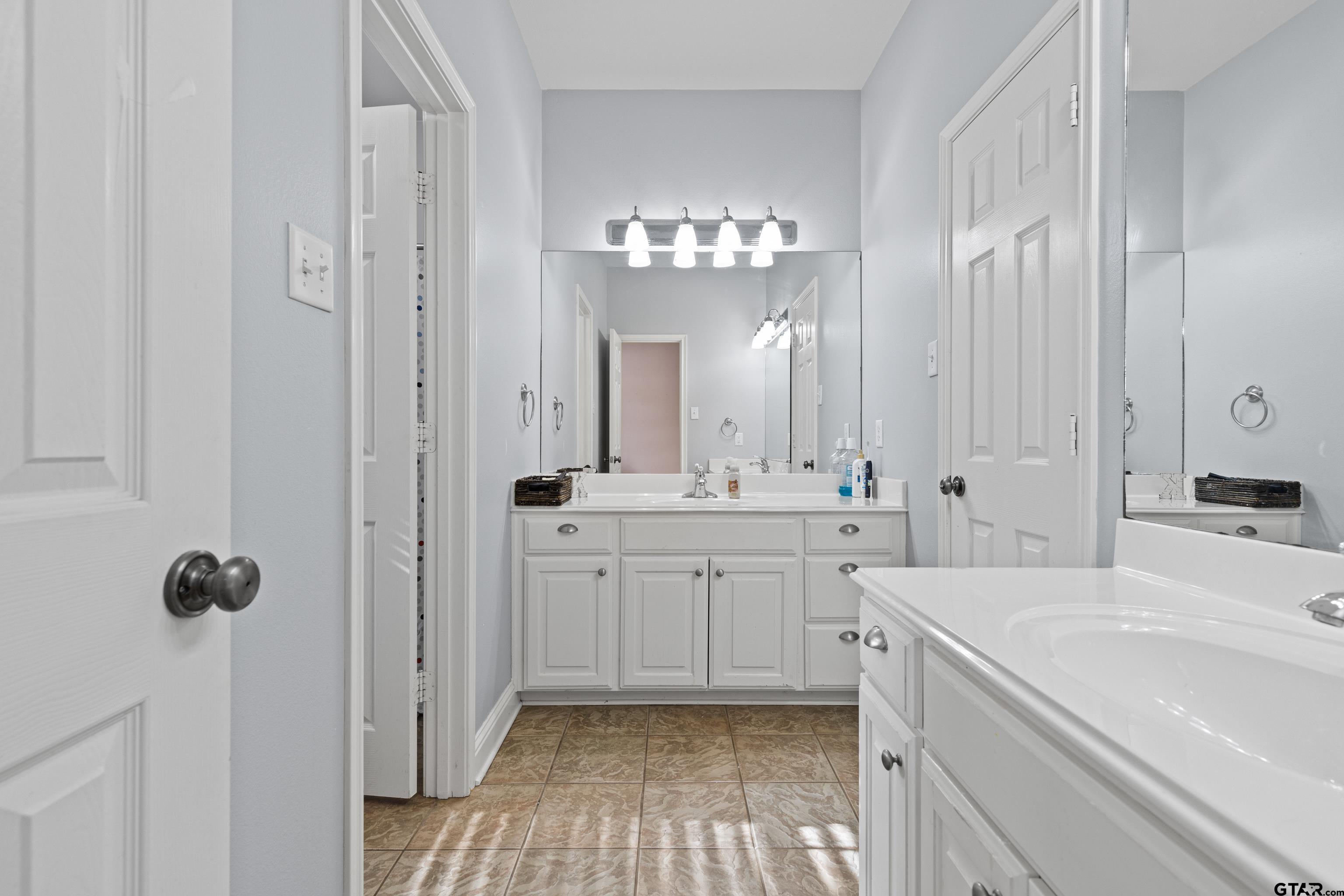 5201 Whitaker Circle Longview, TX 75605 - Photo 27 of 40 a spacious bathroom with a double vanity sink a mirror and a bathtub
