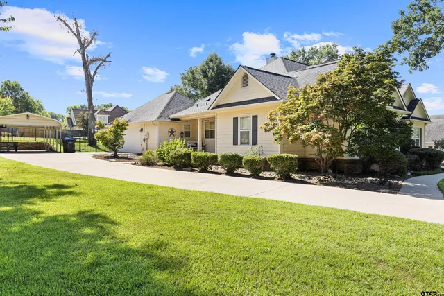 a front view of a house with a yard and potted plants