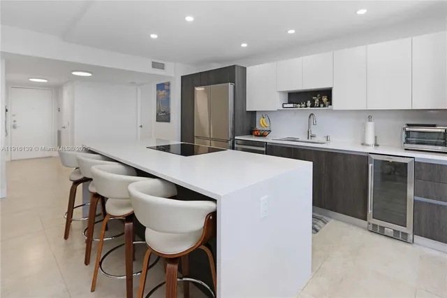 a kitchen with stainless steel appliances a table chairs refrigerator and microwave