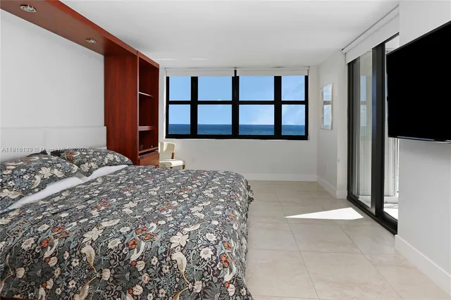 a large bedroom with a bed and a flat screen tv