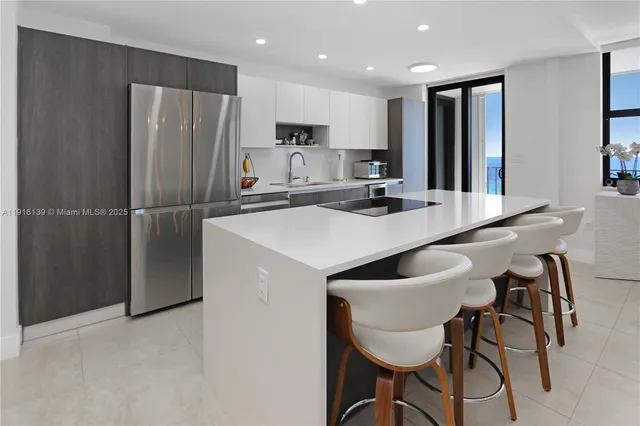a kitchen with refrigerator and chairs