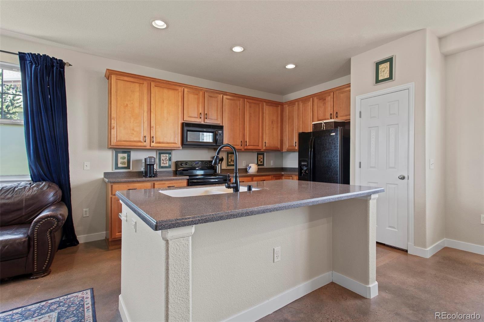 3703 South Perth Circle, Unit 101 Aurora, CO 80013 - Photo 12 of 30 a kitchen with kitchen island a refrigerator stove and sink
