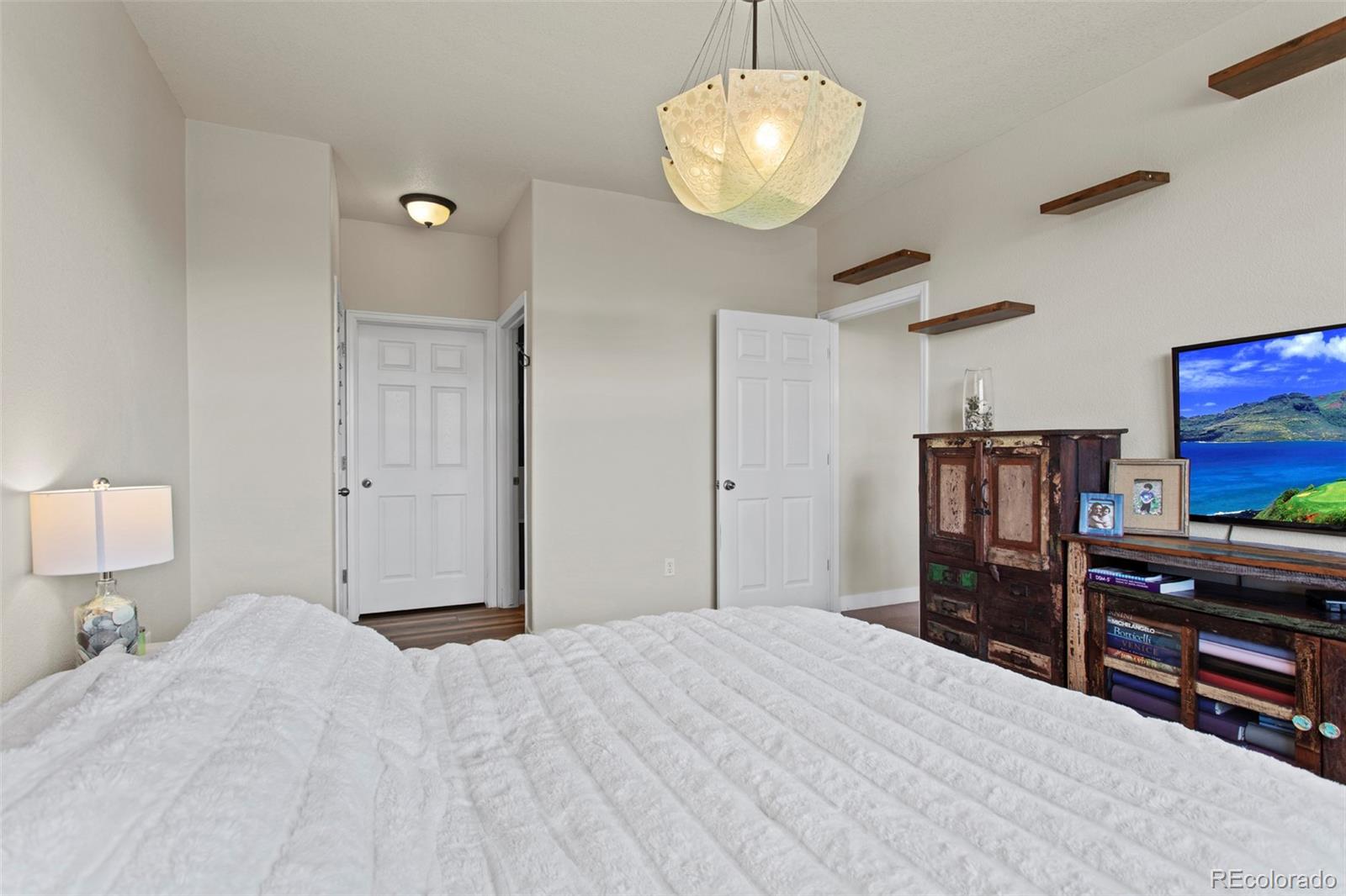 3703 South Perth Circle, Unit 101 Aurora, CO 80013 - Photo 14 of 30 a bedroom with a bed and a flat screen tv