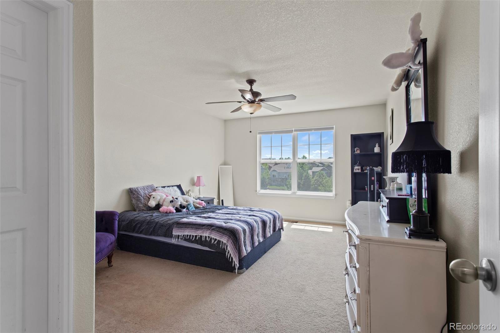 3703 South Perth Circle, Unit 101 Aurora, CO 80013 - Photo 23 of 30 a bedroom with a bed and a chandelier