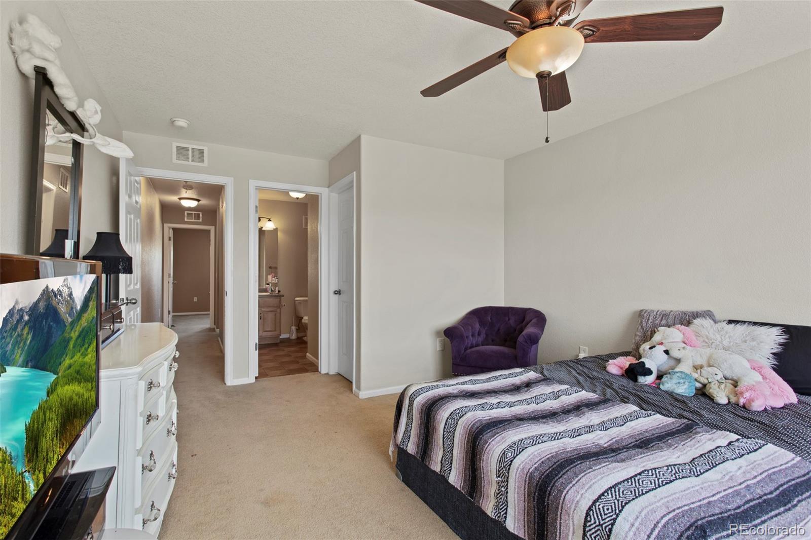 3703 South Perth Circle, Unit 101 Aurora, CO 80013 - Photo 24 of 30 a bedroom with a bed and ceiling fan