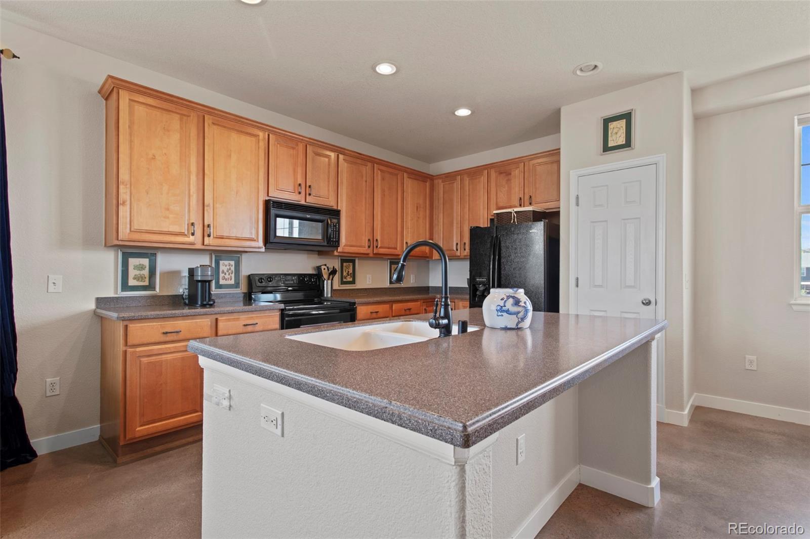 3703 South Perth Circle, Unit 101 Aurora, CO 80013 - Photo 6 of 30 a kitchen with stainless steel appliances granite countertop a refrigerator stove microwave sink and cabinets