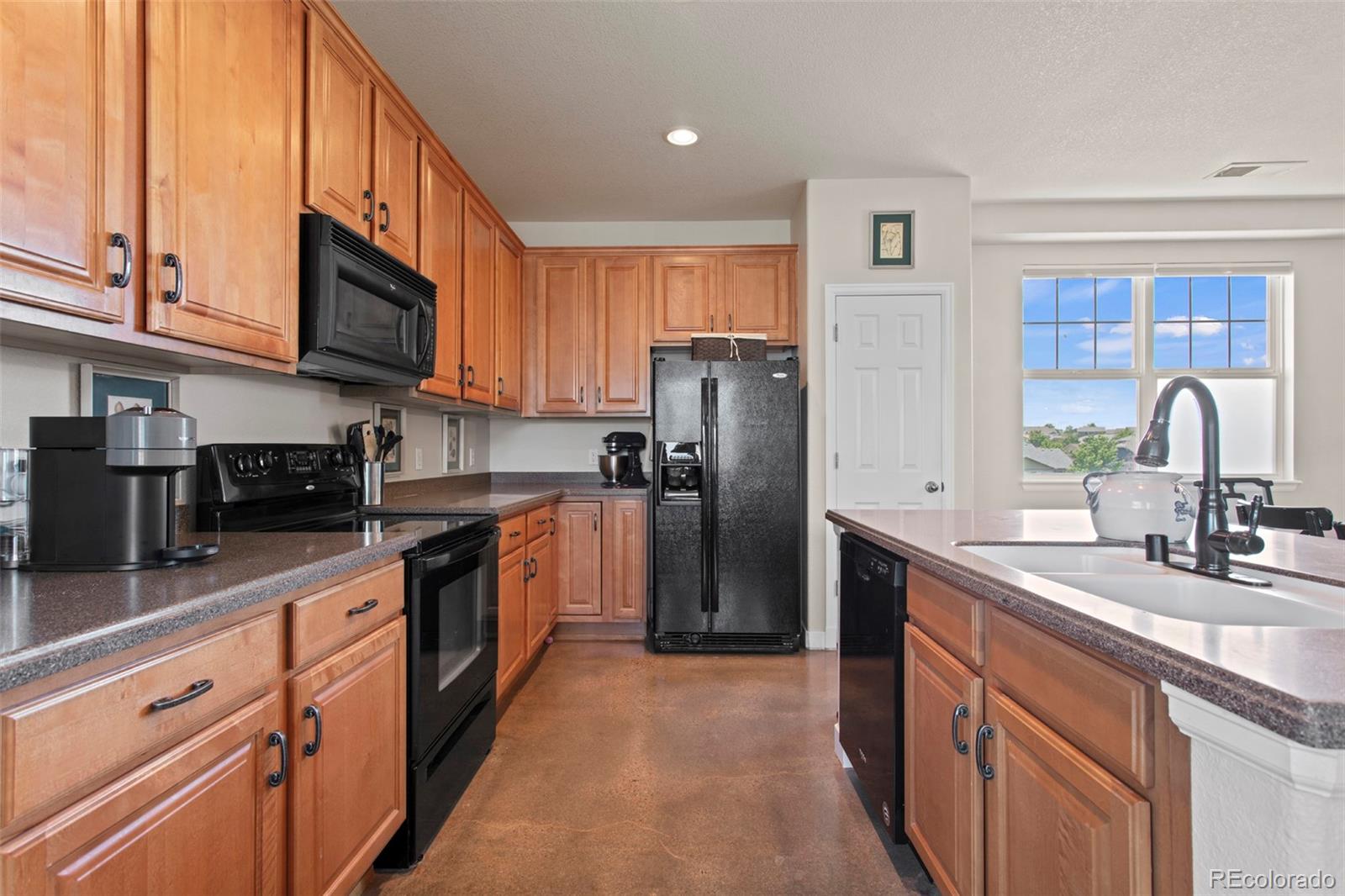 3703 South Perth Circle, Unit 101 Aurora, CO 80013 - Photo 7 of 30 a kitchen with stainless steel appliances granite countertop a refrigerator a stove a sink and a microwave