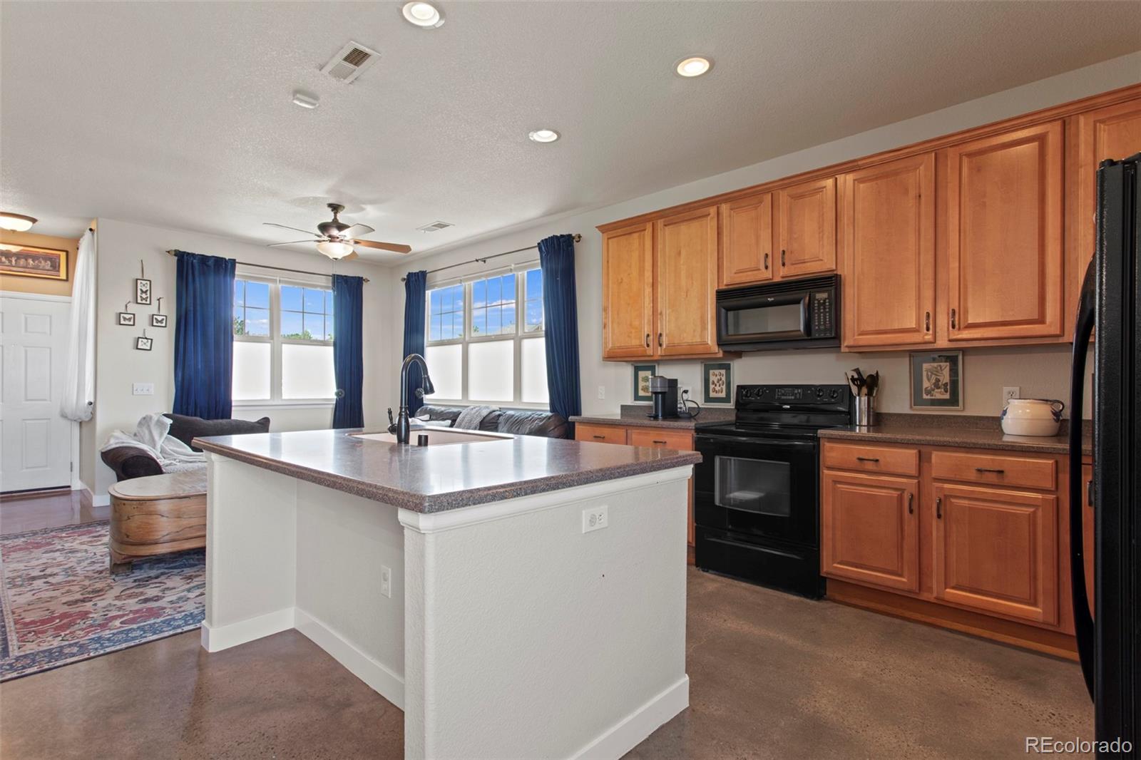 3703 South Perth Circle, Unit 101 Aurora, CO 80013 - Photo 8 of 30 a kitchen with kitchen island granite countertop a sink appliances cabinets and furniture