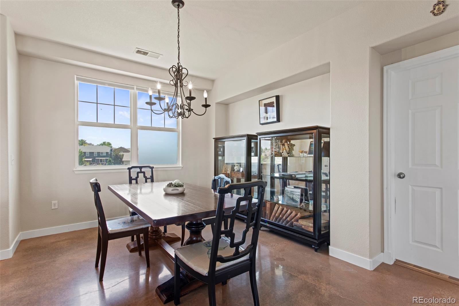 3703 South Perth Circle, Unit 101 Aurora, CO 80013 - Photo 10 of 30 a dining room with furniture a chandelier and window