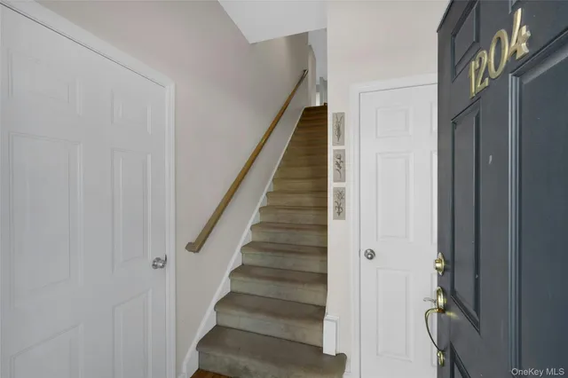 a view of staircase with wooden floor and white walls