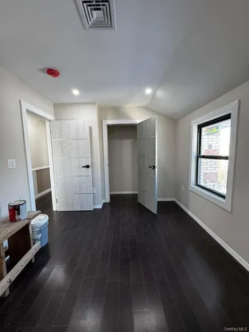 a view of empty room with wooden floor and window