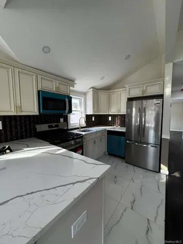 a kitchen with a refrigerator a microwave a sink and cabinets