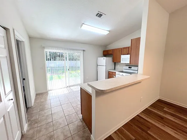 a kitchen with stainless steel appliances granite countertop a refrigerator a sink dishwasher a stove with white cabinets