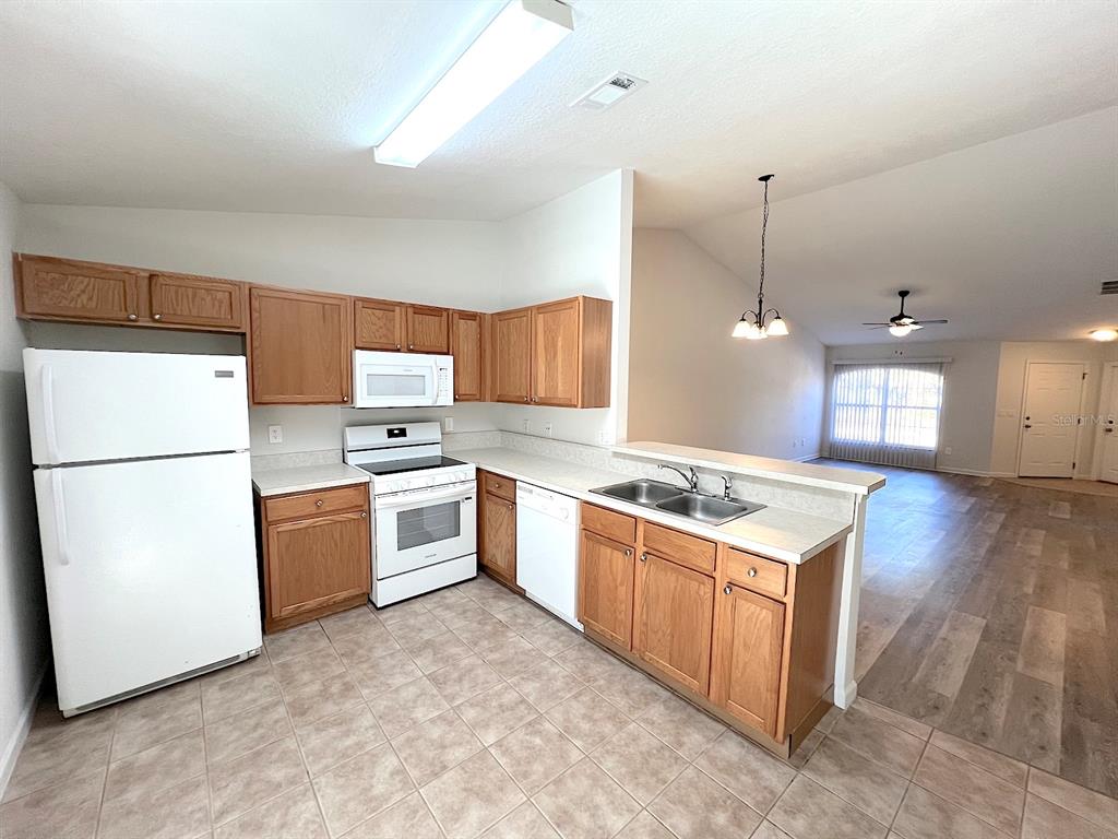 20 Plateau Lane, Unit A Palm Coast, FL 32164 - Photo 15 of 37 a kitchen with stainless steel appliances granite countertop a refrigerator a sink dishwasher a stove with white cabinets