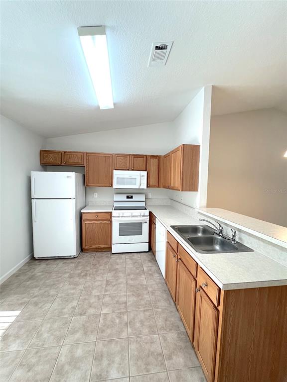 20 Plateau Lane, Unit A Palm Coast, FL 32164 - Photo 17 of 37 a kitchen with stainless steel appliances a white stove top oven a sink a chimney and wooden cabinets