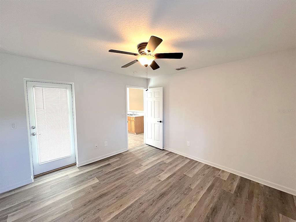20 Plateau Lane, Unit A Palm Coast, FL 32164 - Photo 20 of 37 a view of a room with wooden floor and a ceiling fan