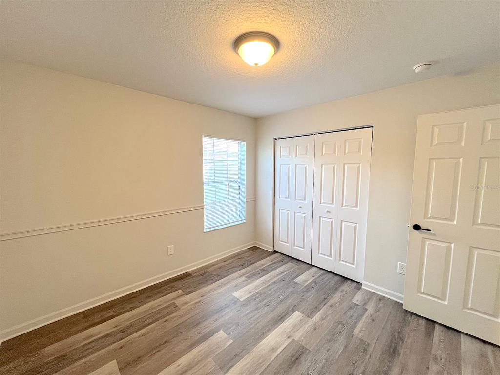 20 Plateau Lane, Unit A Palm Coast, FL 32164 - Photo 29 of 37 an empty room with wooden floor and windows
