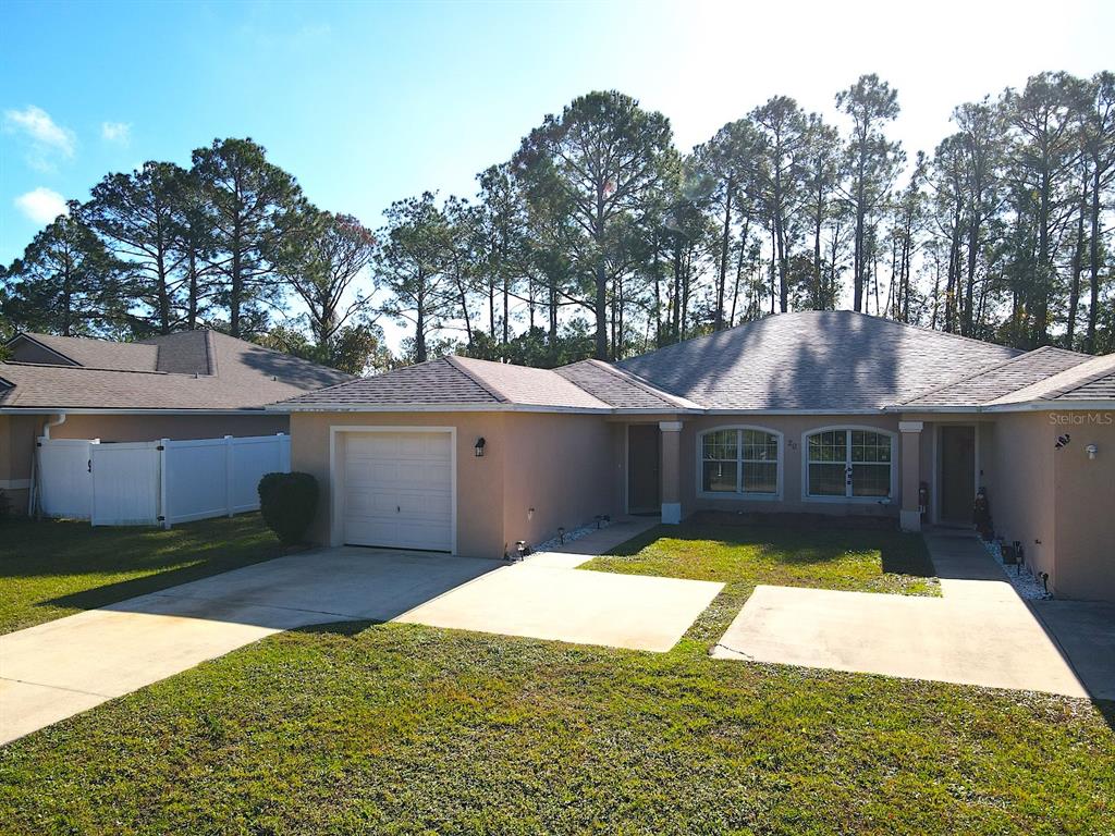 20 Plateau Lane, Unit A Palm Coast, FL 32164 - Photo 3 of 37 a view of a house with a yard potted plants and a large tree
