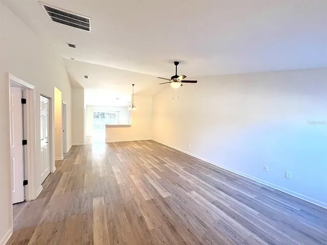 a view of a room with wooden floor and ceiling fan