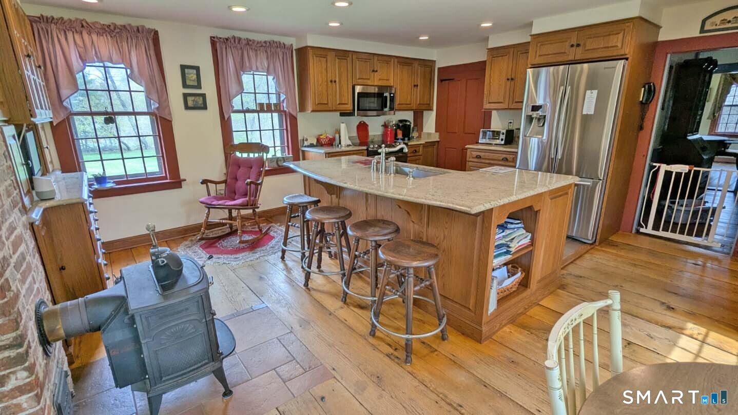 355 Wall Street Hebron, CT 06248 - Photo 11 of 39 a view of a kitchen with kitchen island granite countertop a refrigerator stove microwave and cabinets