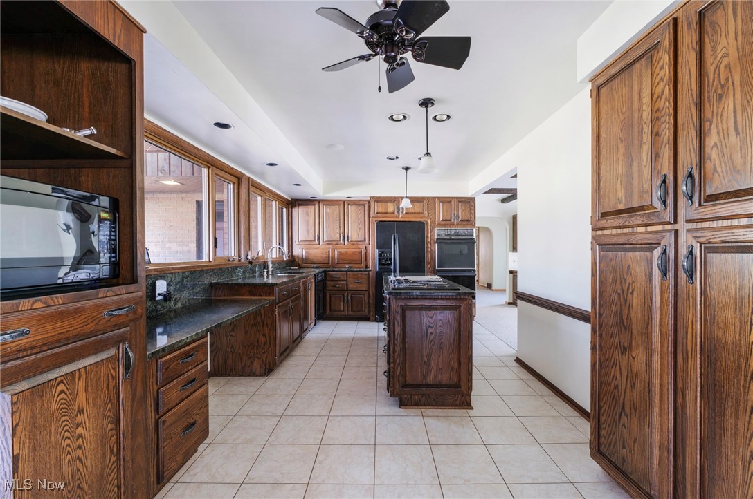 7059 Stewart Sharon Road Hubbard, OH 44425 - Photo 19 of 49 Kitchen featuring a kitchen island, ceiling fan, light tile patterned floors, black appliances, and a sink