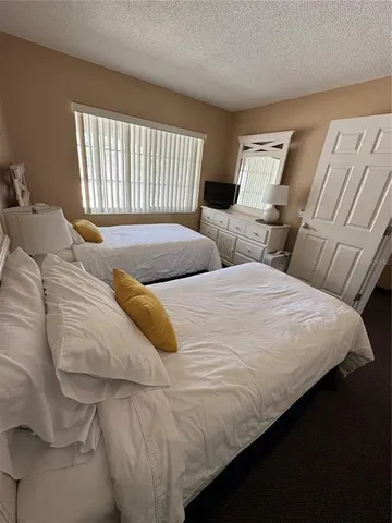 a bedroom with two beds and a large window