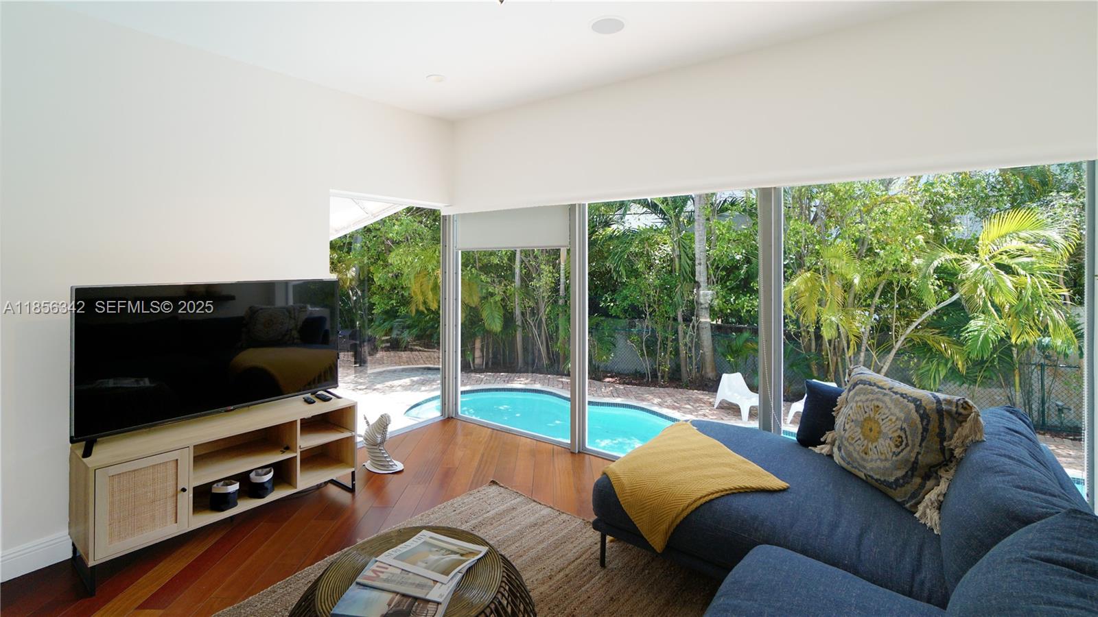 691 Ridgewood Road Key Biscayne, FL 33149 - Photo 16 of 67 a living room with furniture and a flat screen tv