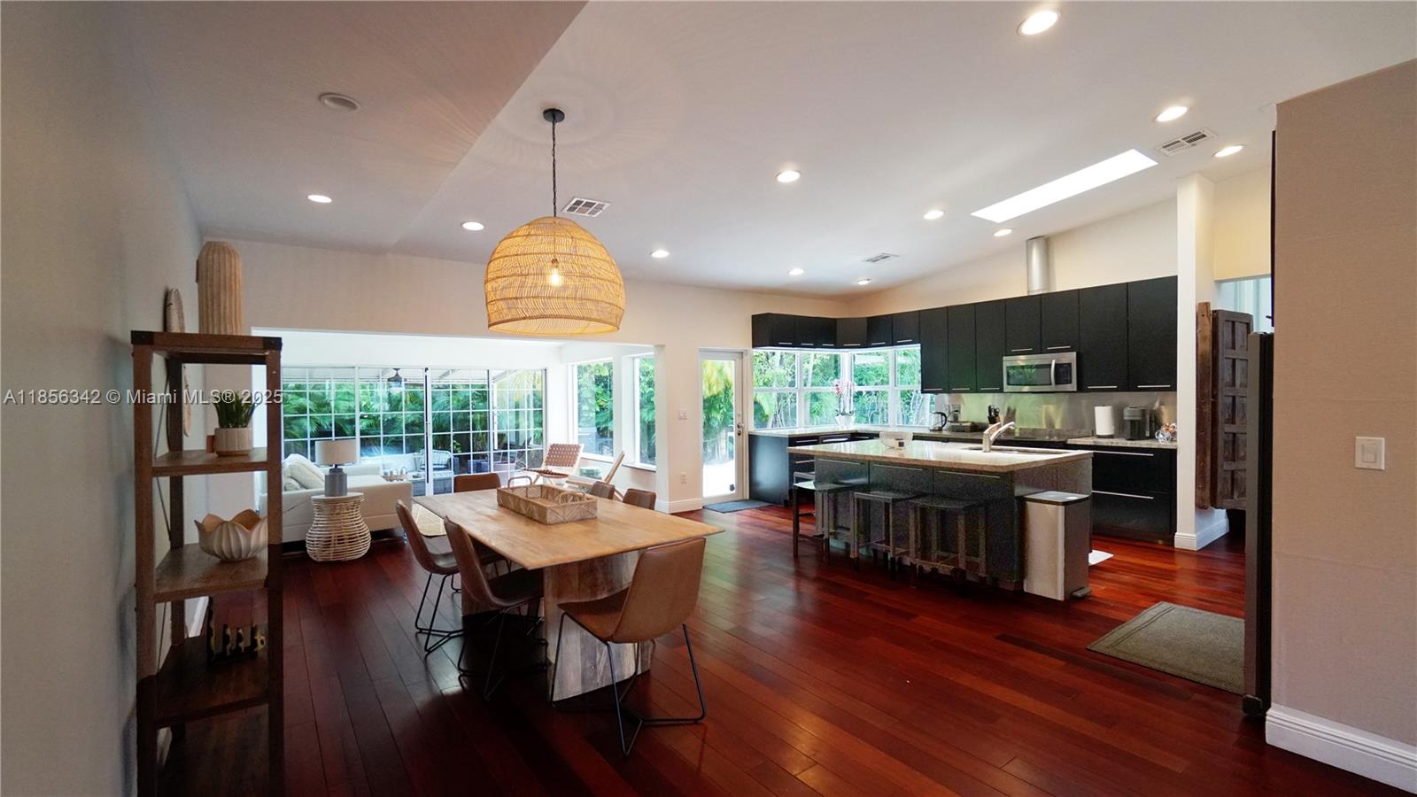 691 Ridgewood Road Key Biscayne, FL 33149 - Photo 19 of 67 a kitchen with stainless steel appliances granite countertop a stove refrigerator and a dining table with wooden floor