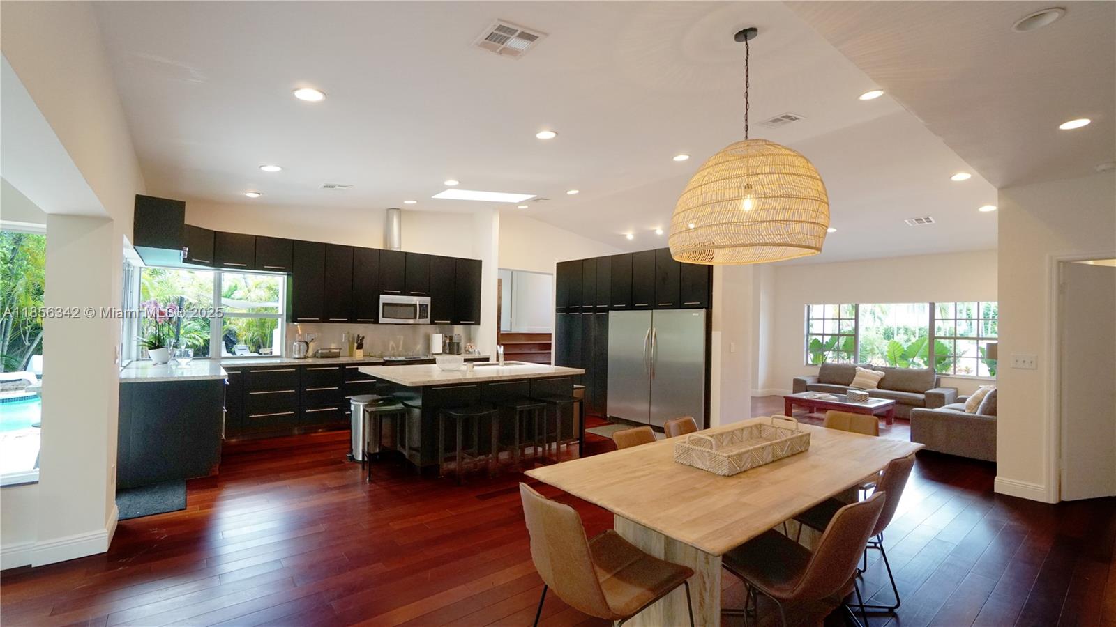 691 Ridgewood Road Key Biscayne, FL 33149 - Photo 20 of 67 a view of a dining room with furniture a kitchen and chandelier