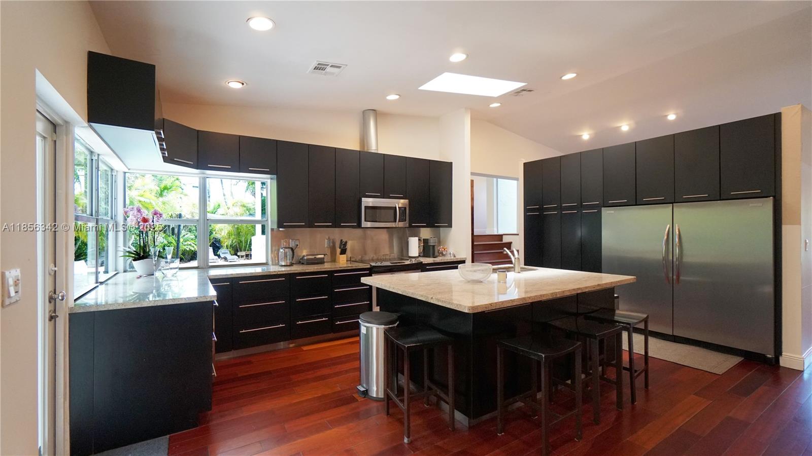 691 Ridgewood Road Key Biscayne, FL 33149 - Photo 21 of 67 a kitchen with stainless steel appliances granite countertop a refrigerator a sink dishwasher a stove and a refrigerator with wooden floor