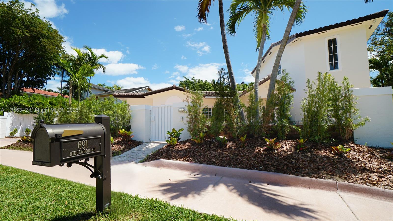 691 Ridgewood Road Key Biscayne, FL 33149 - Photo 3 of 67 a front view of a house with garden