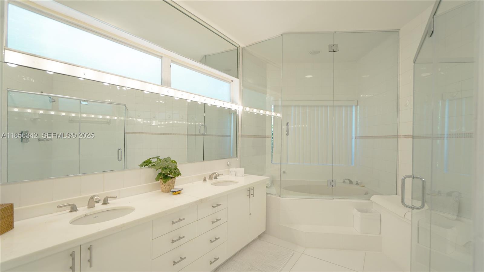 691 Ridgewood Road Key Biscayne, FL 33149 - Photo 32 of 67 a bathroom with a tub sink and mirror