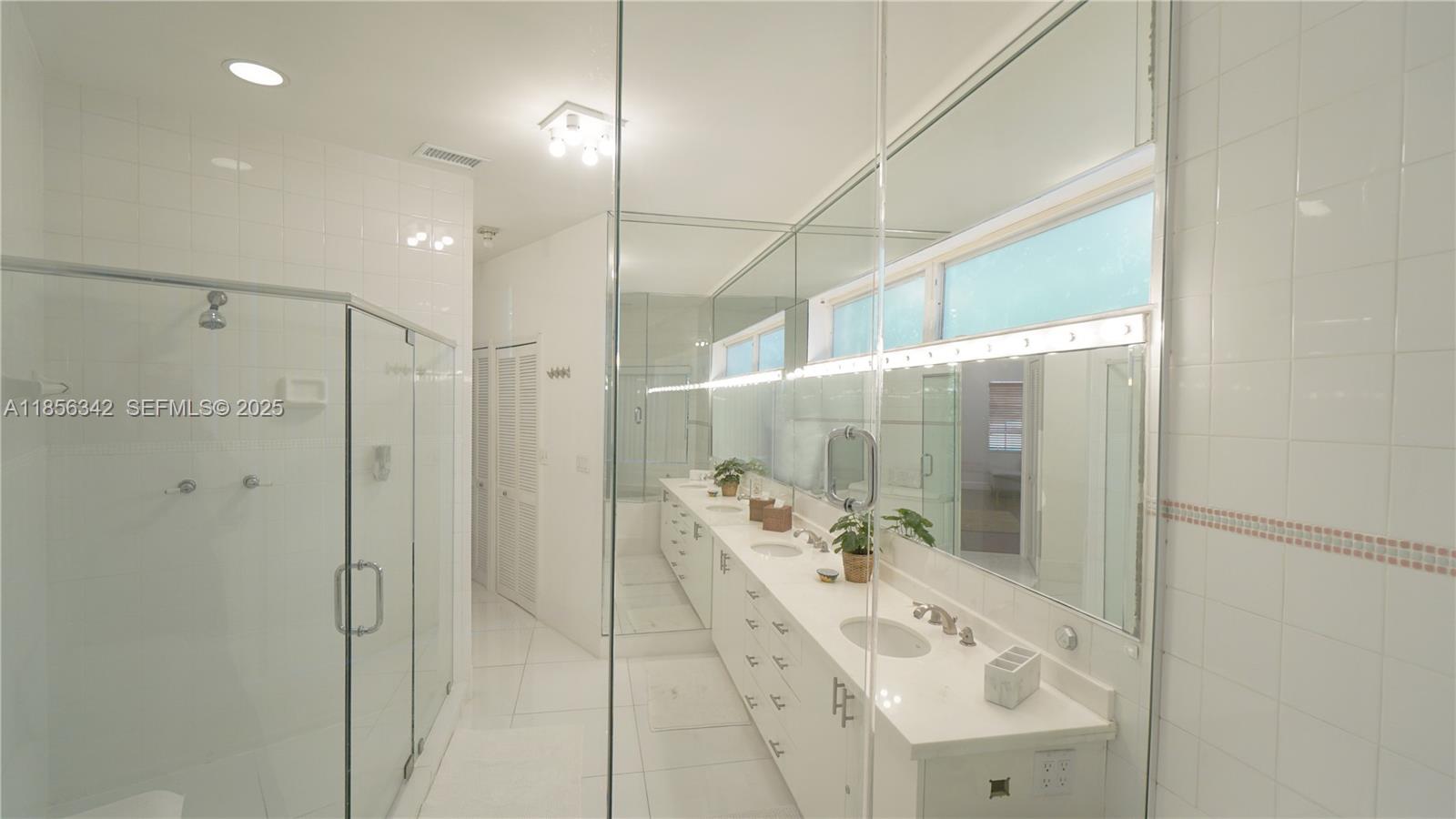 691 Ridgewood Road Key Biscayne, FL 33149 - Photo 34 of 67 a bathroom with a shower sink and mirror