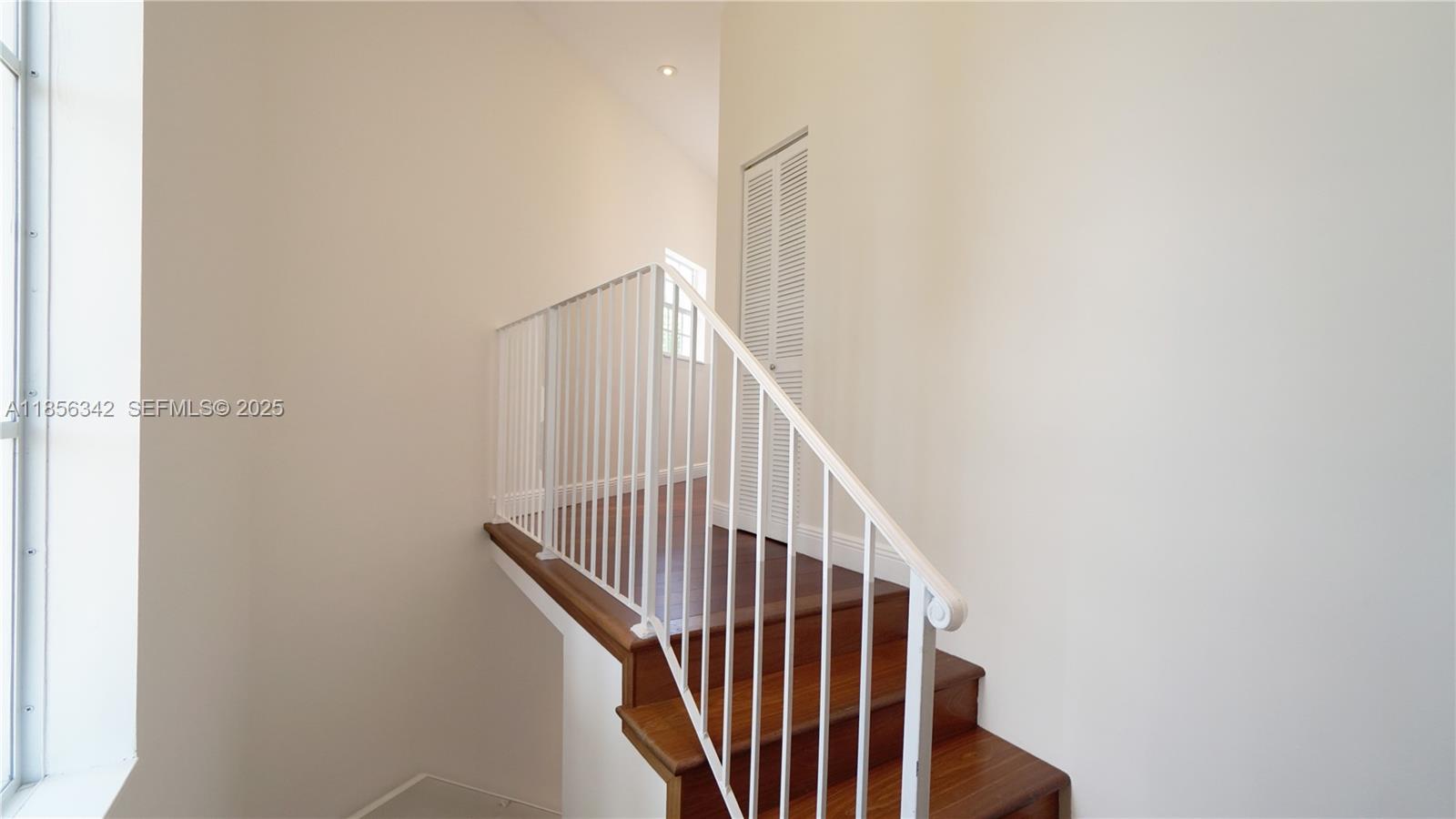 691 Ridgewood Road Key Biscayne, FL 33149 - Photo 43 of 67 a view of staircase with railing and white walls