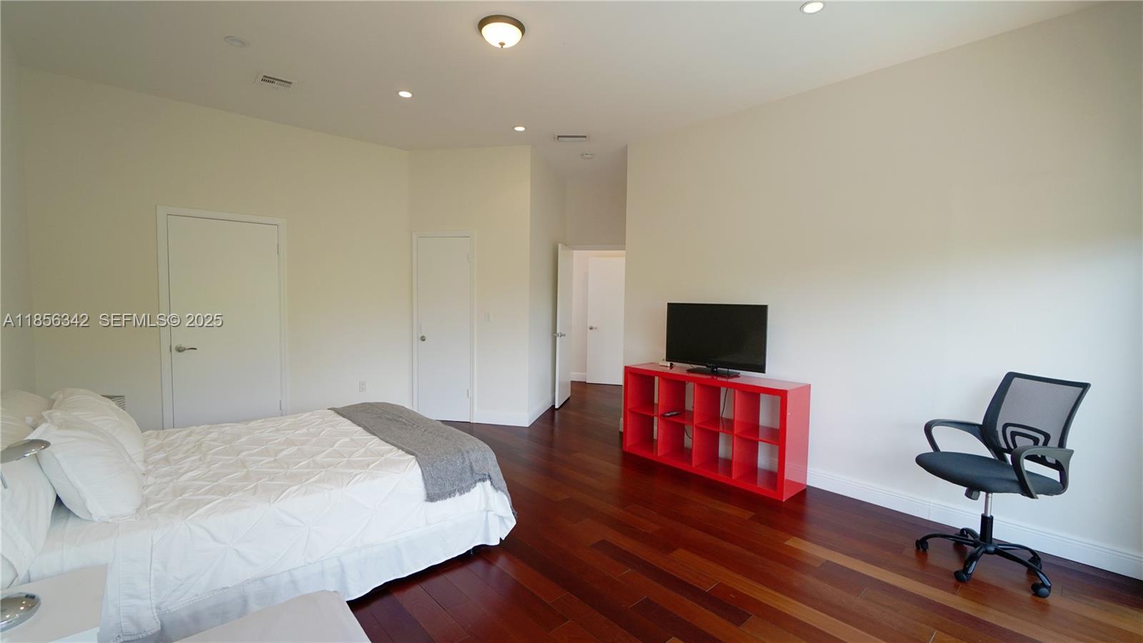 691 Ridgewood Road Key Biscayne, FL 33149 - Photo 45 of 67 a bedroom with a bed and a chair